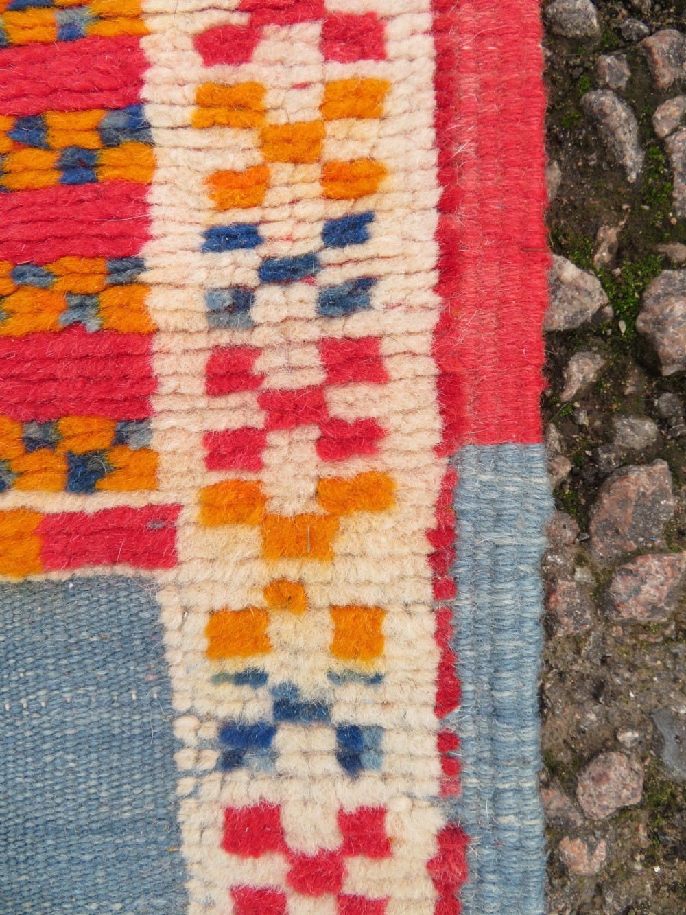 An extra long and narrow handwoven Moroccan Berber runner rug featuring geometric panels in pink, light blue, yellow, and navy with fringed ends. View XIII