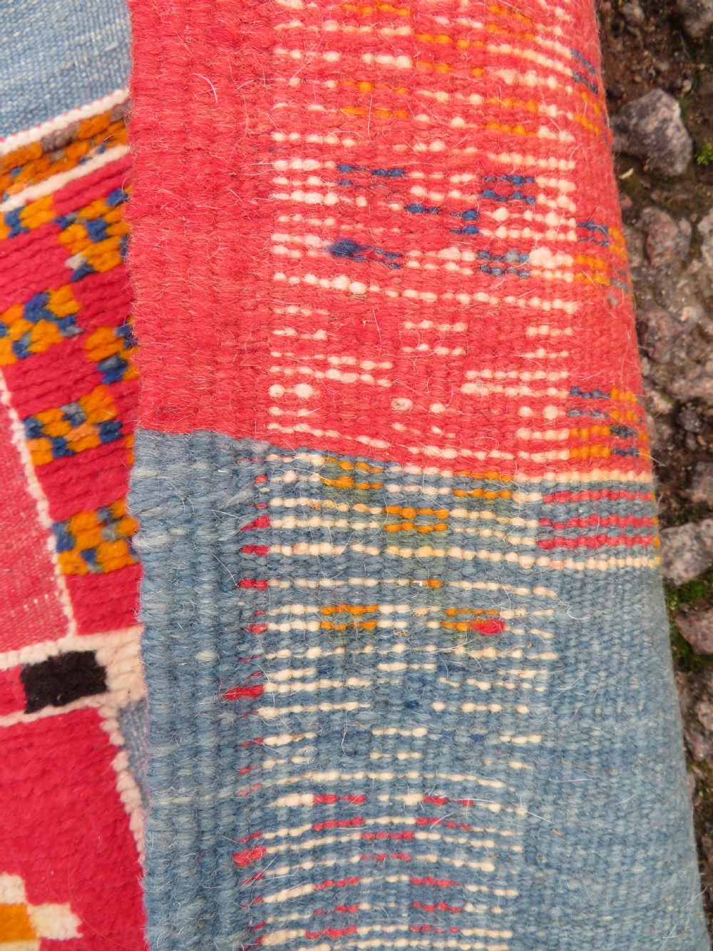 An extra long and narrow handwoven Moroccan Berber runner rug featuring geometric panels in pink, light blue, yellow, and navy with fringed ends. View XIV
