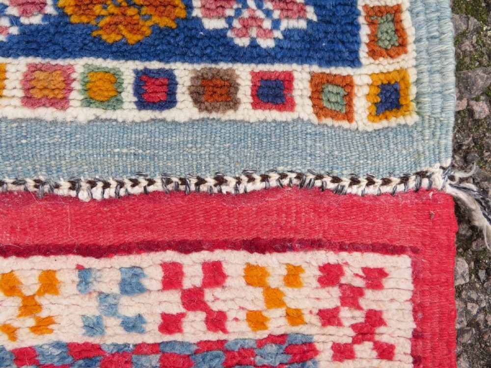 An extra long and narrow handwoven Moroccan Berber runner rug featuring geometric panels in pink, light blue, yellow, and navy with fringed ends. View XVI