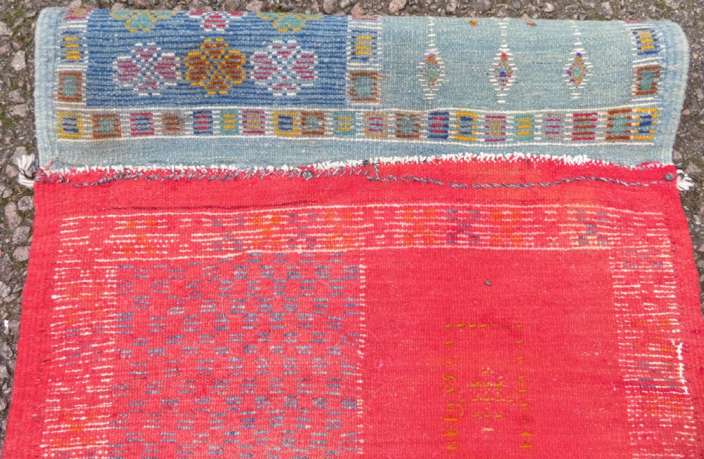 An extra long and narrow handwoven Moroccan Berber runner rug featuring geometric panels in pink, light blue, yellow, and navy with fringed ends. View XVIII