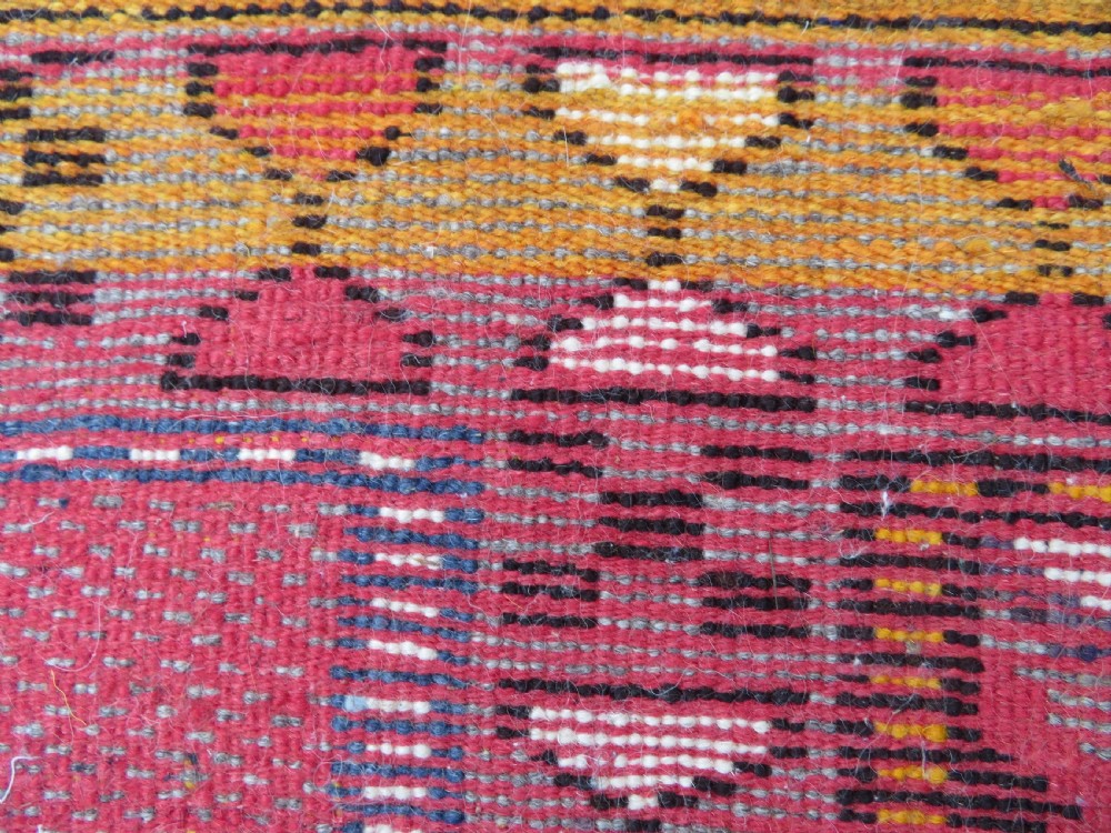 A rectangular hand-knotted Moroccan Berber wool rug featuring geometric patchwork panels in pink, yellow, black, grey, and white with fringed ends. View XIII