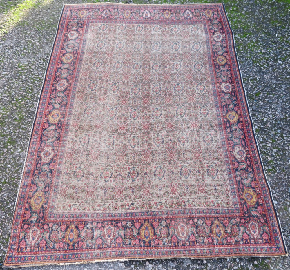 A nineteenth-century Persian Fereghan wool rug featuring an intricate all-over floral lattice pattern framed by navy and terracotta borders.