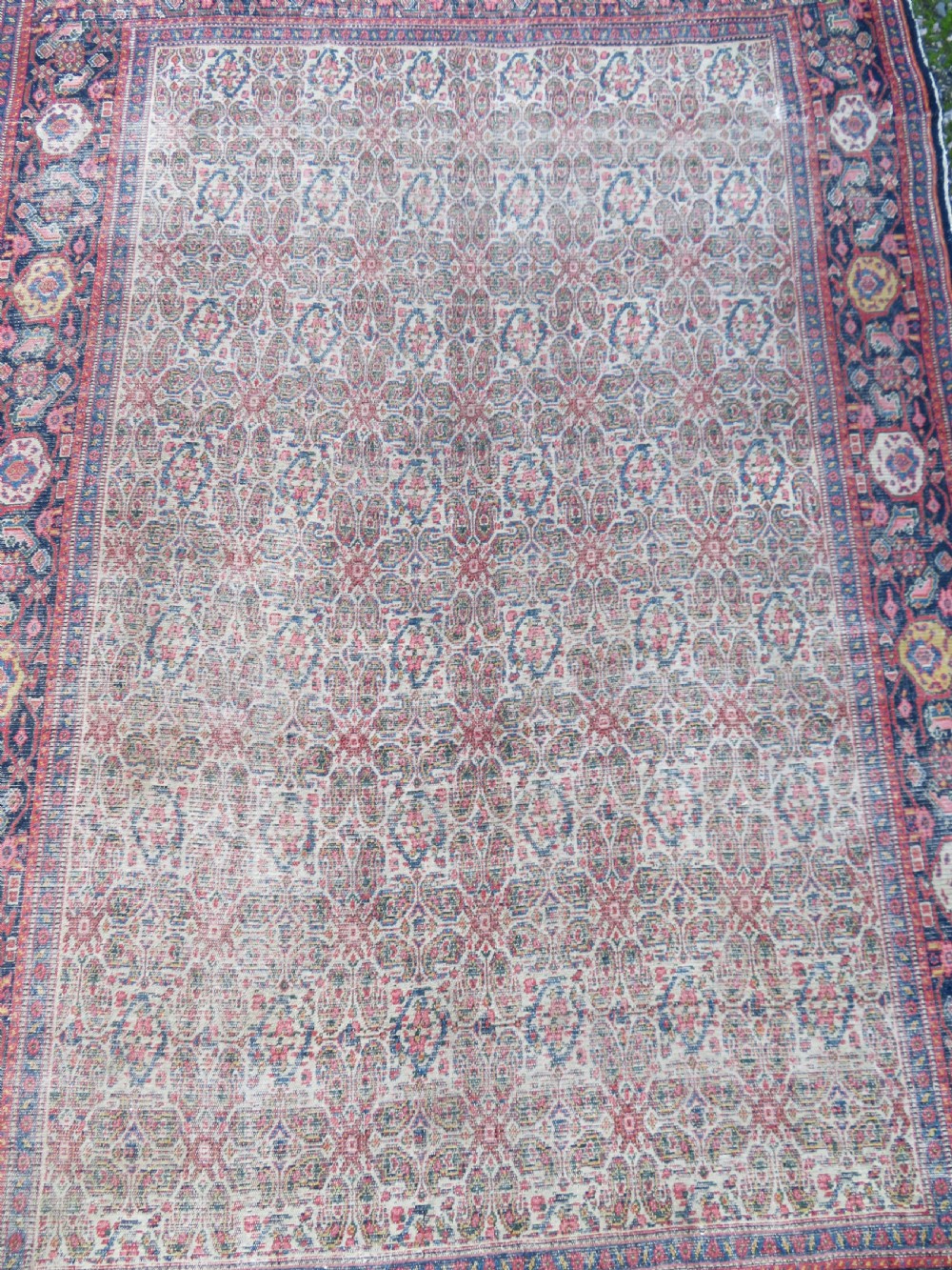 A nineteenth-century Persian Fereghan wool rug featuring an intricate all-over floral lattice pattern framed by navy and terracotta borders. View III