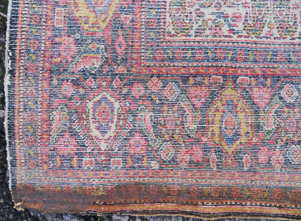 A nineteenth-century Persian Fereghan wool rug featuring an intricate all-over floral lattice pattern framed by navy and terracotta borders. View XIX