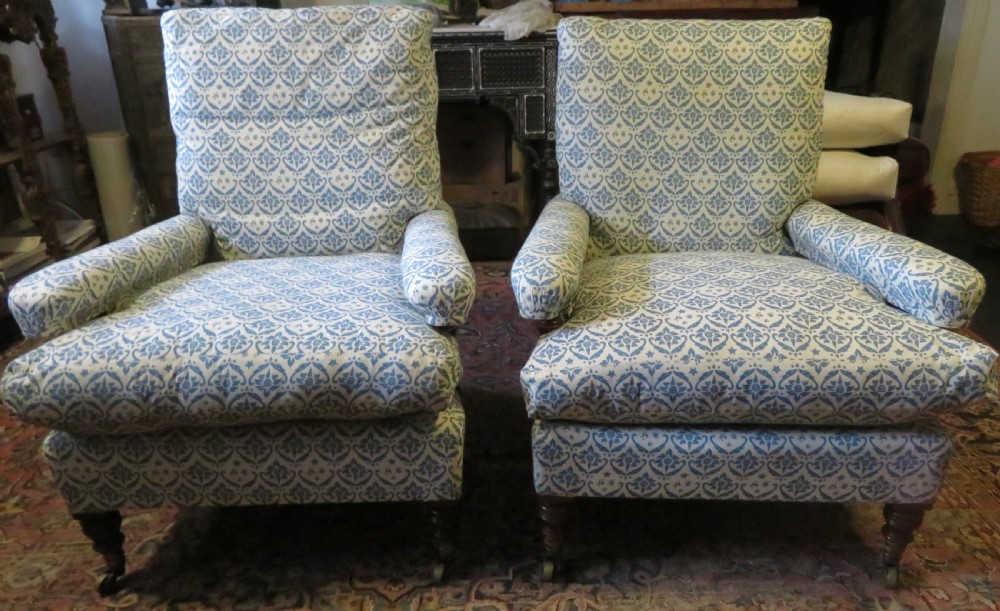 PAIR HOWARD AND SONS OPEN ARMCHAIRS.