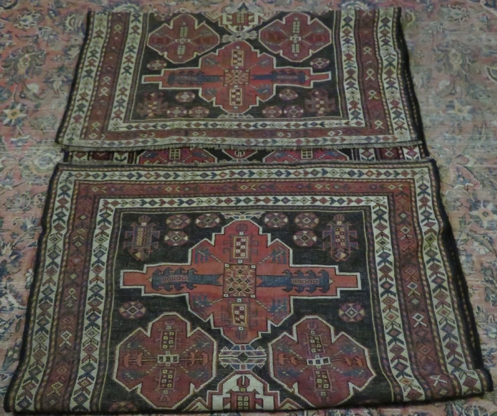 A long hand-knotted antique Kurdish Kelleh wool rug featuring geometric diamond medallions in red and navy blue on a dark brown field with patterned borders. View XVIII