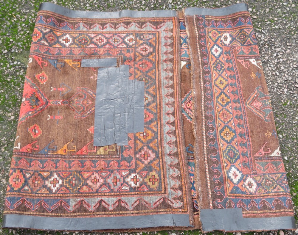 An antique Kurdish hand-knotted long wool rug featuring three central red diamond medallions surrounded by geometric tribal borders on a dark brown field. View XIII