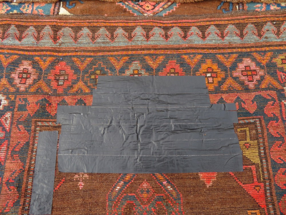 An antique Kurdish hand-knotted long wool rug featuring three central red diamond medallions surrounded by geometric tribal borders on a dark brown field. View XIV