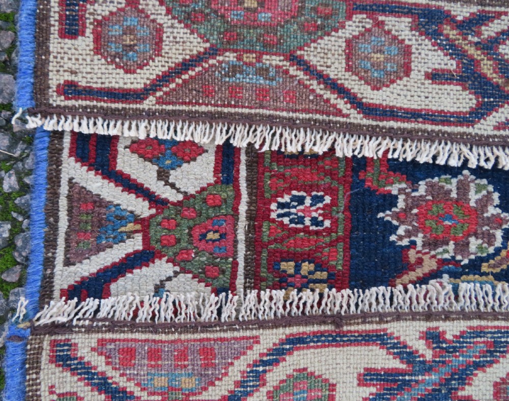 A long, narrow antique Persian Fereghan runner rug featuring detailed floral lattice motifs on a deep navy field framed by multi-tiered terracotta red and cream patterned borders. View XV
