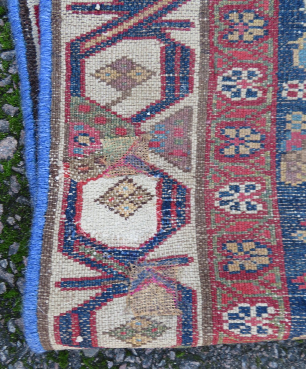 A long, narrow antique Persian Fereghan runner rug featuring detailed floral lattice motifs on a deep navy field framed by multi-tiered terracotta red and cream patterned borders. View XVII