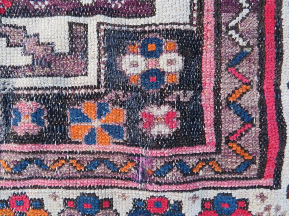 An antique hand-knotted Caucasian Lesghi wool rug featuring geometric star medallions in red, blue, cream, and brown surrounded by decorative pattern borders. View XI