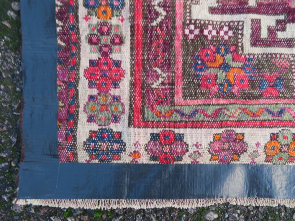 An antique hand-knotted Caucasian Lesghi wool rug featuring geometric star medallions in red, blue, cream, and brown surrounded by decorative pattern borders. View XV