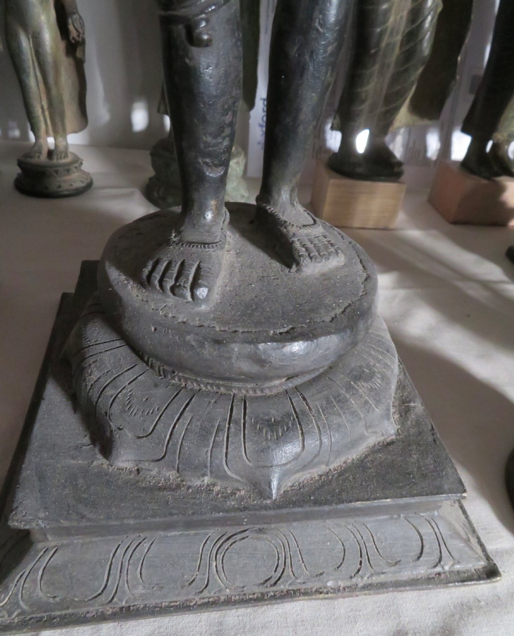 A four-armed dark bronze figure of the Hindu deity Shiva standing atop a stylized lotus base and rectangular pedestal. View V