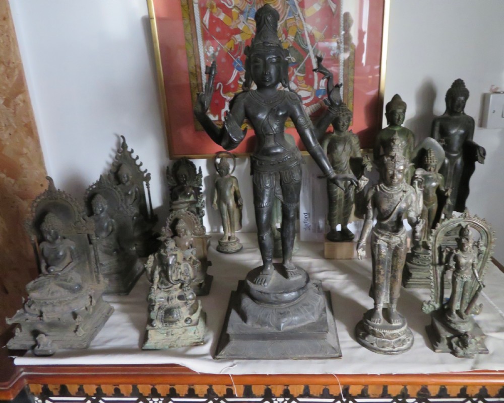 A four-armed dark bronze figure of the Hindu deity Shiva standing atop a stylized lotus base and rectangular pedestal. View XII