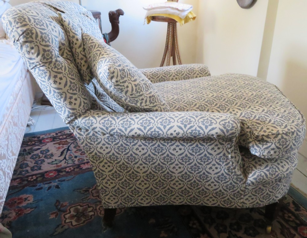 A deep upholstered easy armchair featuring blue and cream patterned fabric with button-back detailing and matching loose cushions. View III