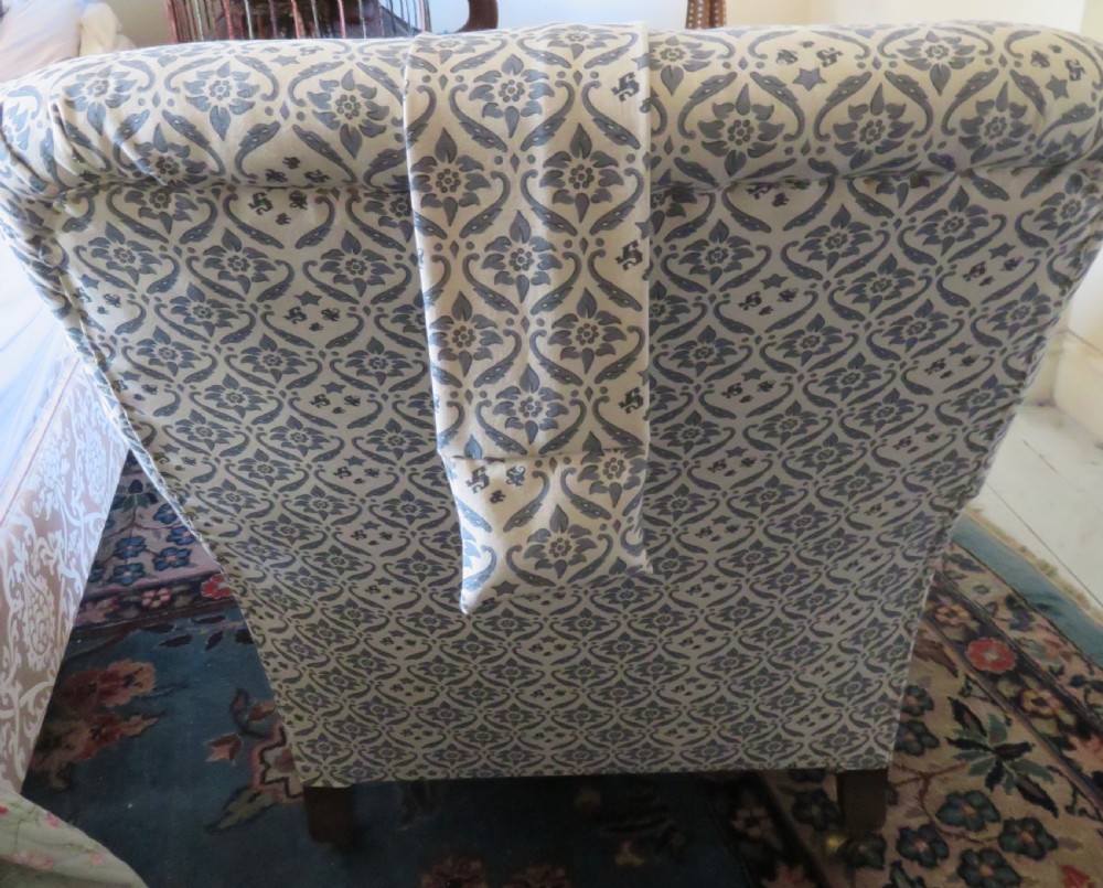 A deep upholstered easy armchair featuring blue and cream patterned fabric with button-back detailing and matching loose cushions. View VI