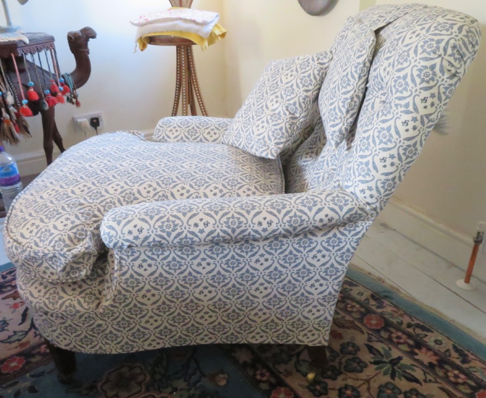 A deep upholstered easy armchair featuring blue and cream patterned fabric with button-back detailing and matching loose cushions. View VIII
