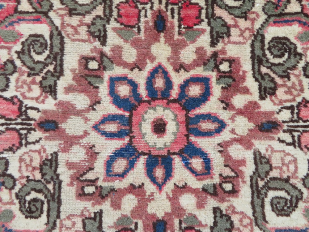 A large rectangular hand-knotted Persian Hamadan wool rug featuring a central floral medallion surrounded by intricate floral motifs in shades of rose pink, cream, brown, and blue. View IV