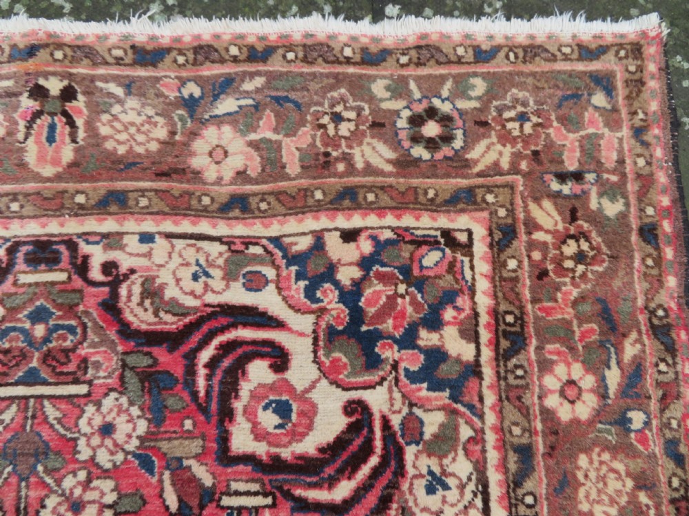 A large rectangular hand-knotted Persian Hamadan wool rug featuring a central floral medallion surrounded by intricate floral motifs in shades of rose pink, cream, brown, and blue. View VI