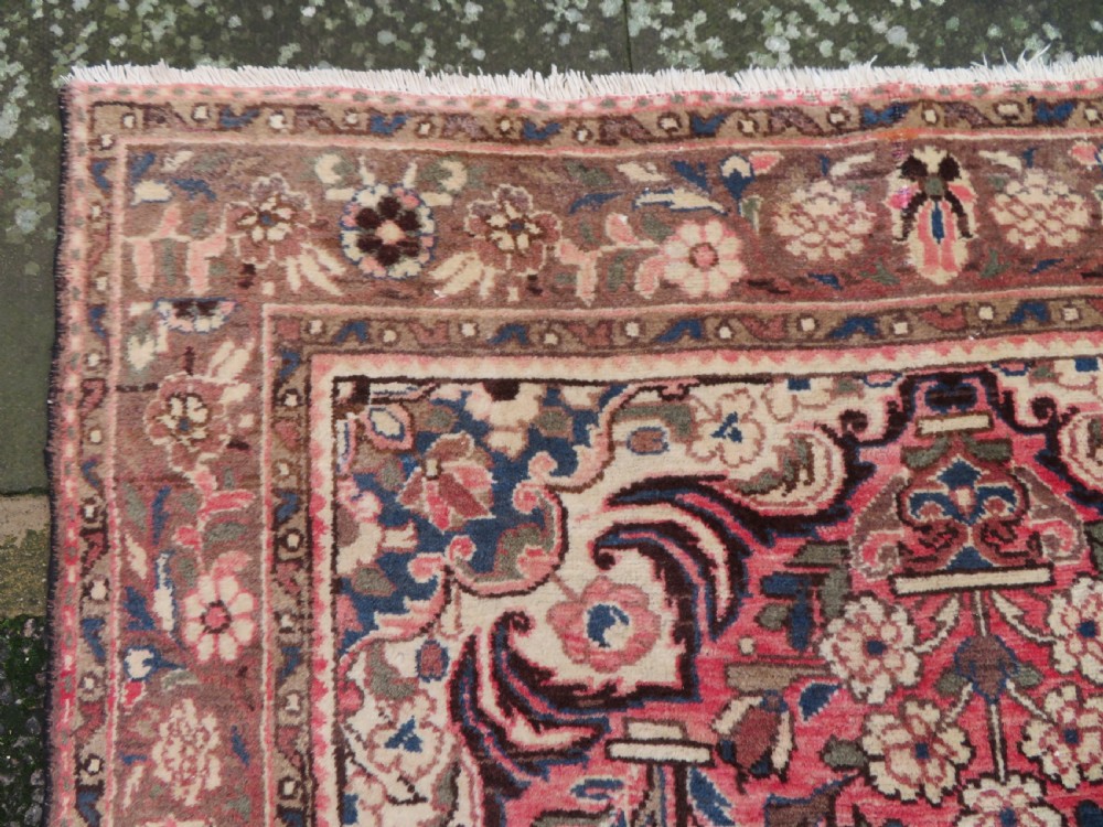 A large rectangular hand-knotted Persian Hamadan wool rug featuring a central floral medallion surrounded by intricate floral motifs in shades of rose pink, cream, brown, and blue. View VII