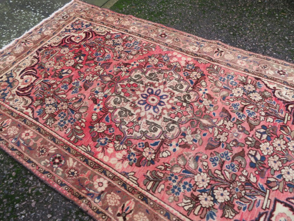 A large rectangular hand-knotted Persian Hamadan wool rug featuring a central floral medallion surrounded by intricate floral motifs in shades of rose pink, cream, brown, and blue. View XII