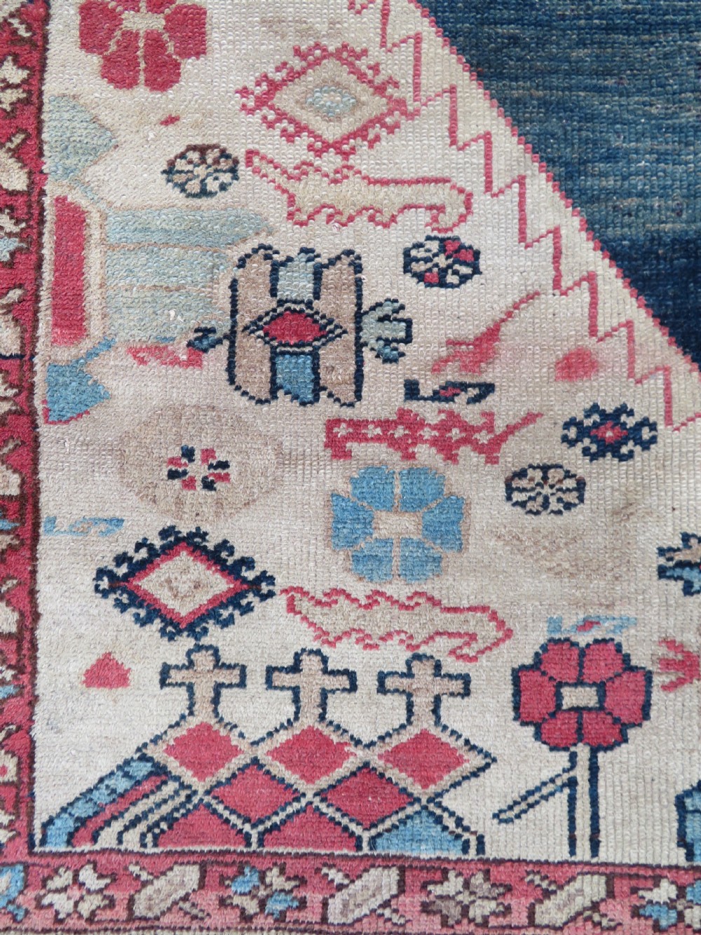 An antique Bakshaish hand-knotted wool rug featuring a navy blue and terracotta central geometric medallion on a cream field with patterned borders. View IV