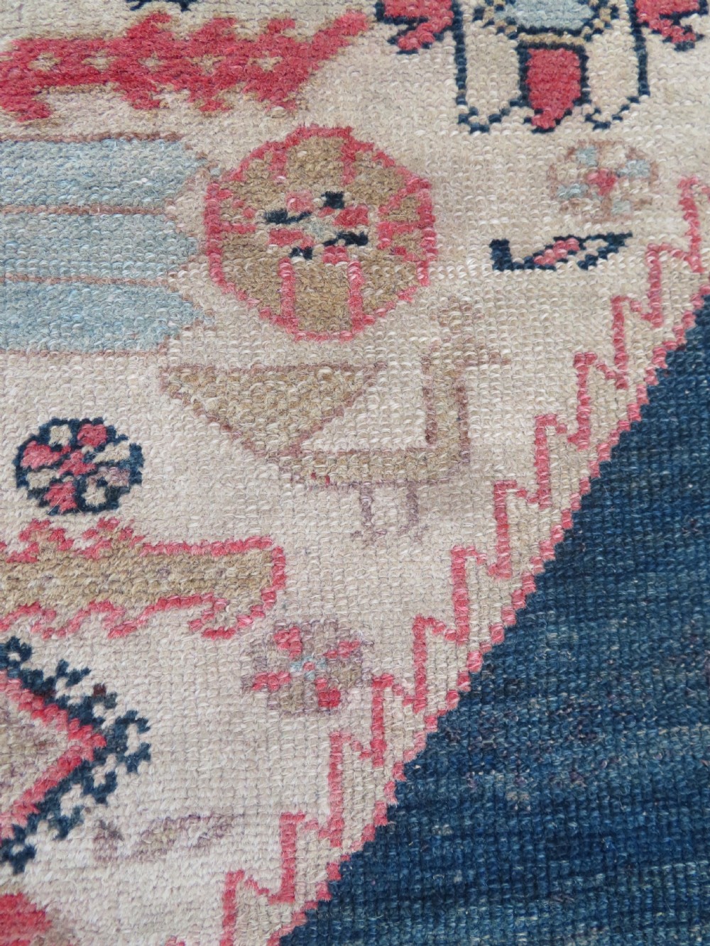 An antique Bakshaish hand-knotted wool rug featuring a navy blue and terracotta central geometric medallion on a cream field with patterned borders. View VII