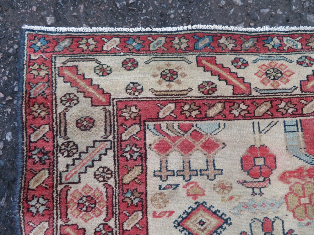 An antique Bakshaish hand-knotted wool rug featuring a navy blue and terracotta central geometric medallion on a cream field with patterned borders. View VIII