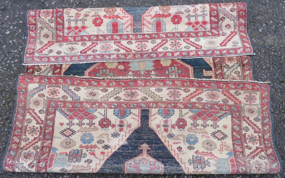 An antique Bakshaish hand-knotted wool rug featuring a navy blue and terracotta central geometric medallion on a cream field with patterned borders. View XIII