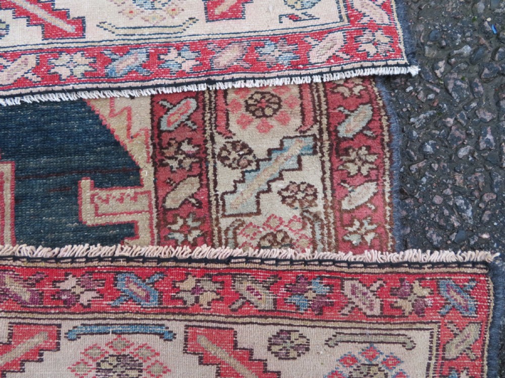 An antique Bakshaish hand-knotted wool rug featuring a navy blue and terracotta central geometric medallion on a cream field with patterned borders. View XIV
