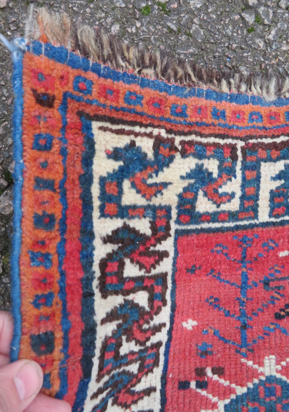 A large hand-knotted Persian Bakhtiari rug featuring geometric diamond medallions on a dark navy field surrounded by a detailed red patterned border. View XVII