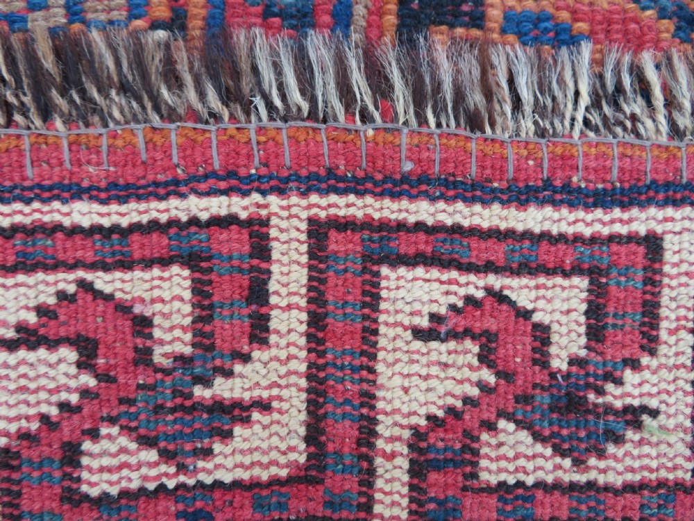 A large hand-knotted Persian Bakhtiari rug featuring geometric diamond medallions on a dark navy field surrounded by a detailed red patterned border. View XX