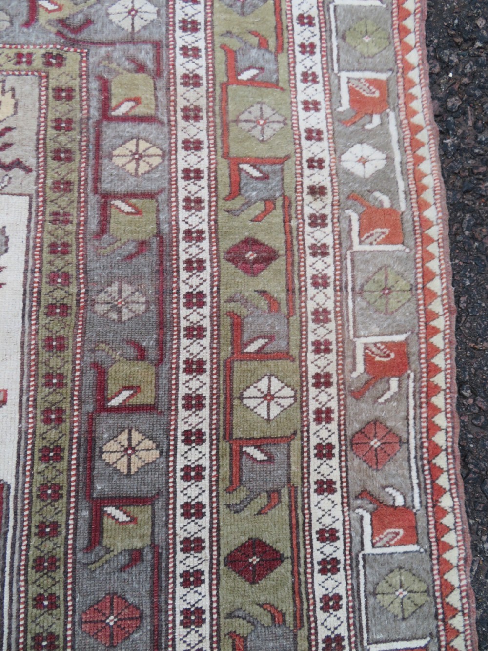A hand-knotted antique Turkish Melas wool carpet featuring a terracotta red geometric diamond medallion on an ivory field with complex geometric borders. View VIII