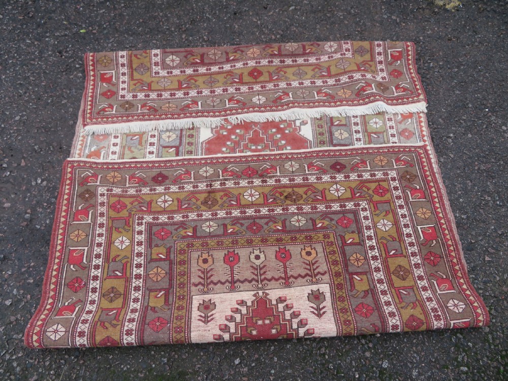 A hand-knotted antique Turkish Melas wool carpet featuring a terracotta red geometric diamond medallion on an ivory field with complex geometric borders. View XI
