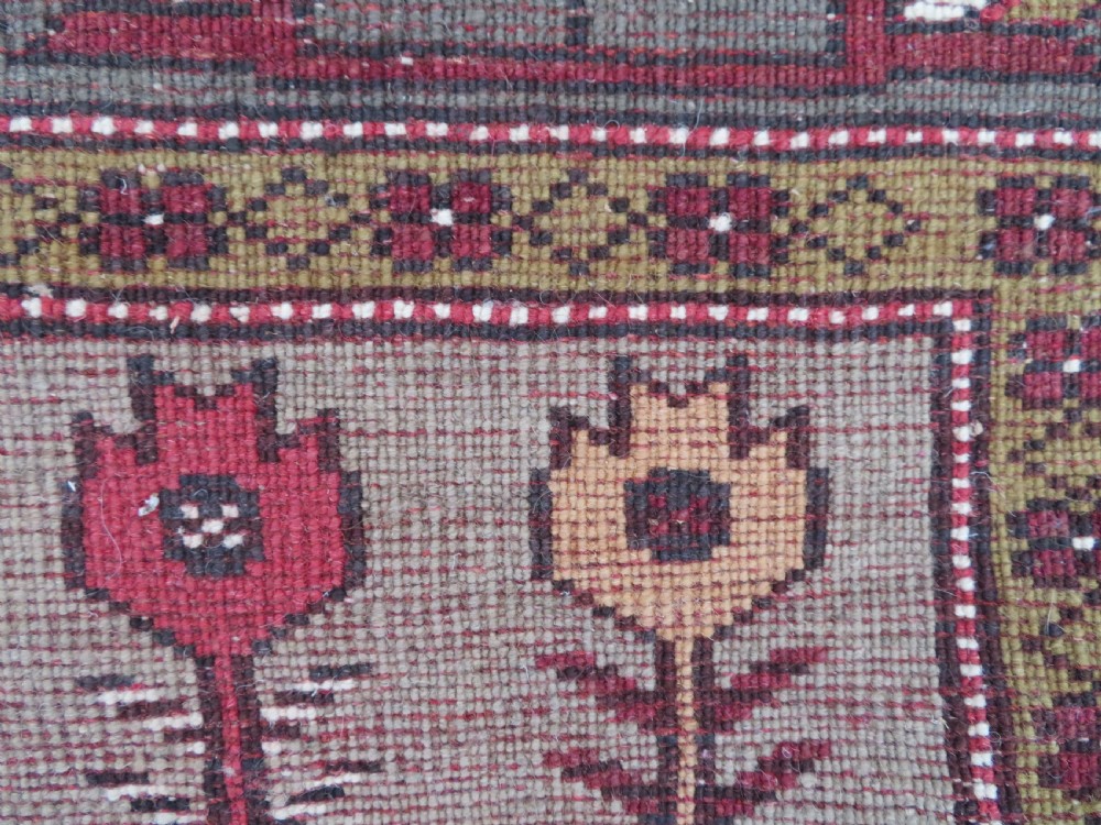 A hand-knotted antique Turkish Melas wool carpet featuring a terracotta red geometric diamond medallion on an ivory field with complex geometric borders. View XIII
