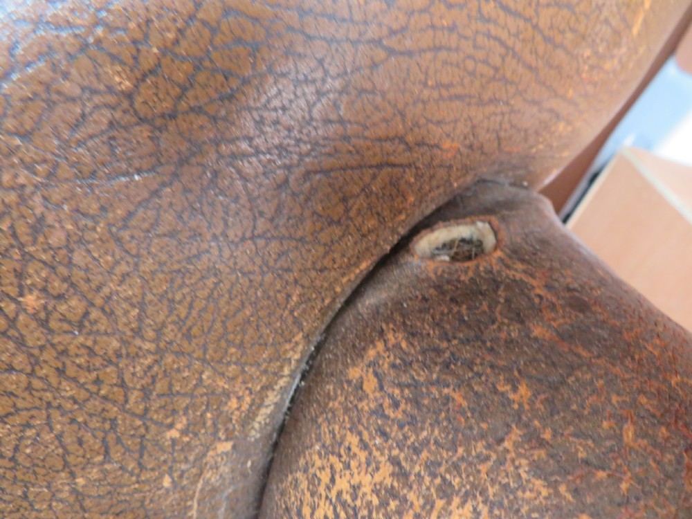 A distressed brown leather Art Deco club armchair with brass stud trimming along the rolled arms and a velvet seat cushion. View XI