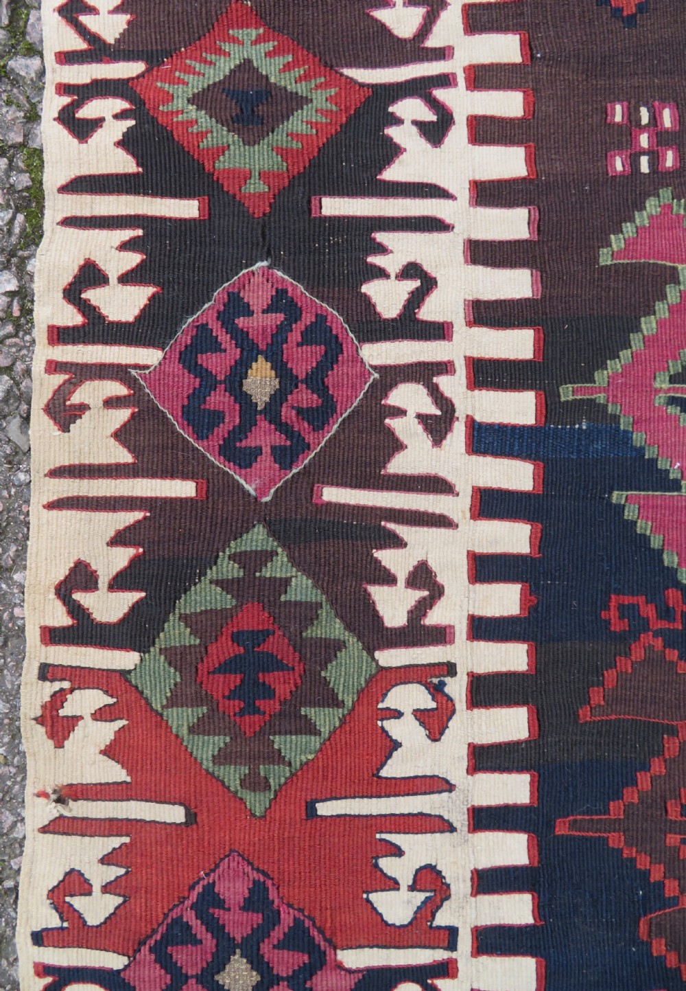 A long handwoven Turkish flatweave Kilim runner featuring intricate geometric diamond medallions in red, navy blue, green, and cream. View IV