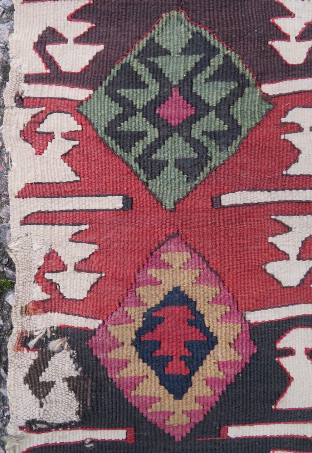 A long handwoven Turkish flatweave Kilim runner featuring intricate geometric diamond medallions in red, navy blue, green, and cream. View V