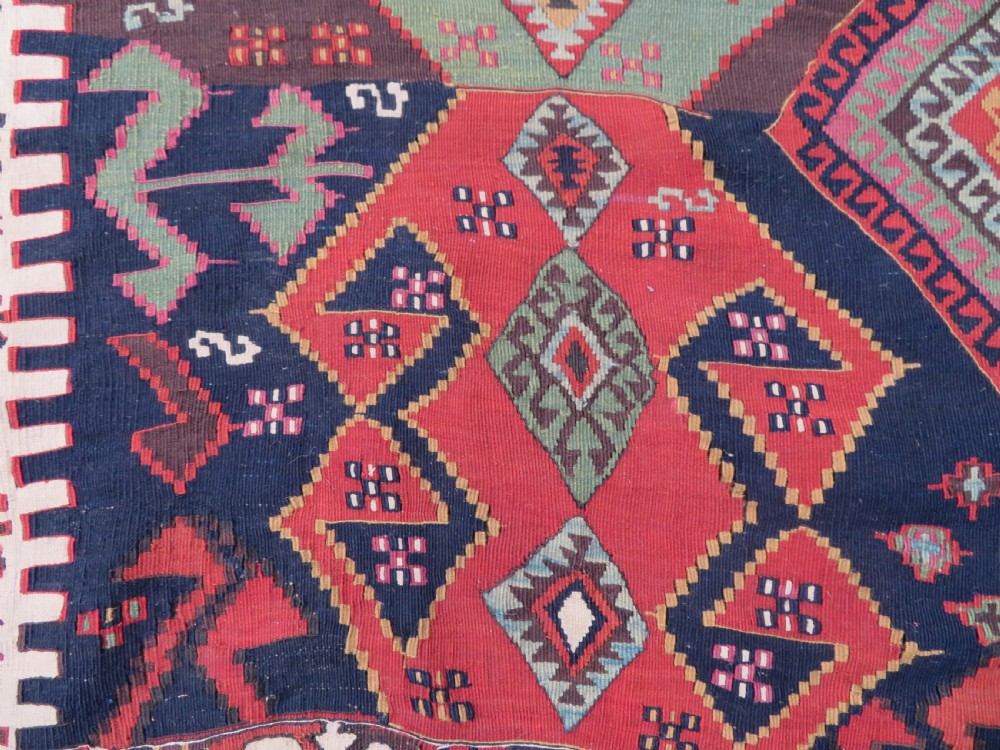 A long handwoven Turkish flatweave Kilim runner featuring intricate geometric diamond medallions in red, navy blue, green, and cream. View VIII