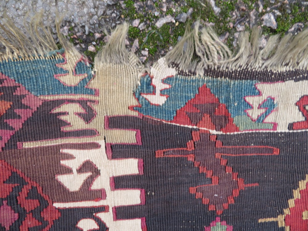 A long handwoven Turkish flatweave Kilim runner featuring intricate geometric diamond medallions in red, navy blue, green, and cream. View IX
