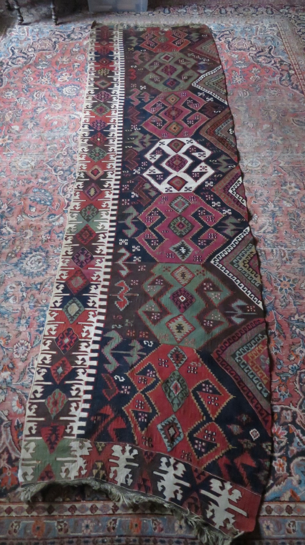 A long handwoven Turkish flatweave Kilim runner featuring intricate geometric diamond medallions in red, navy blue, green, and cream. View XII