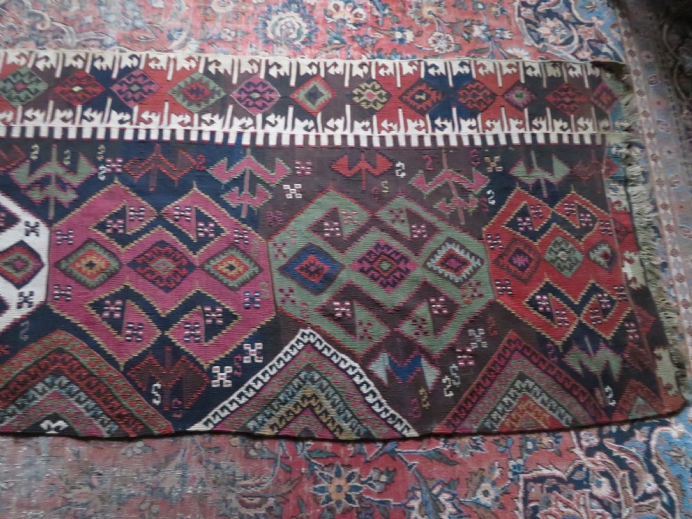 A long handwoven Turkish flatweave Kilim runner featuring intricate geometric diamond medallions in red, navy blue, green, and cream. View XIII