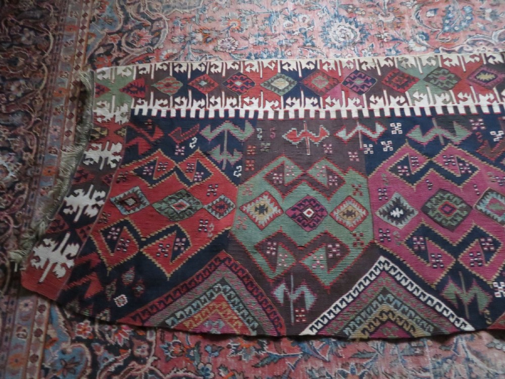 A long handwoven Turkish flatweave Kilim runner featuring intricate geometric diamond medallions in red, navy blue, green, and cream. View XIV