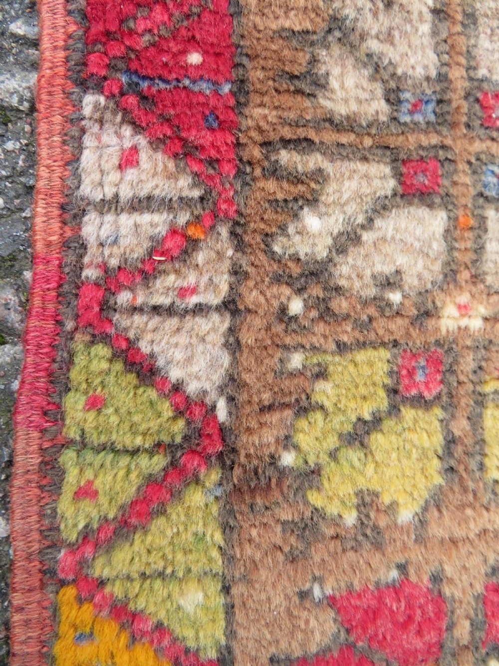 An antique hand-knotted Turkish Mujur wool rug featuring a stepped central medallion on a red field with patterned borders and fringed edges. View IX