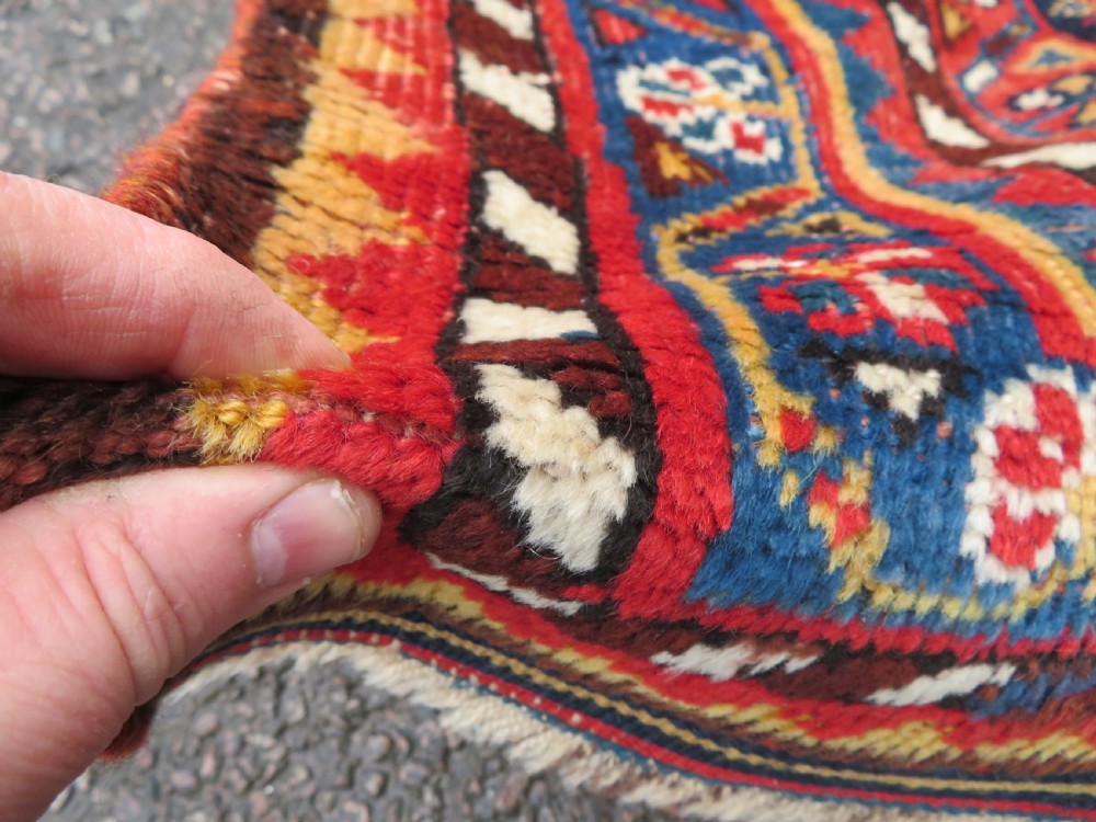 An antique hand-knotted wool kelleh rug featuring a central tree of life motif in red, yellow, and light blue against a dark navy field. View VII