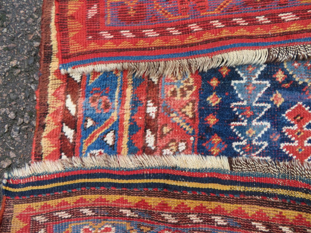 An antique hand-knotted wool kelleh rug featuring a central tree of life motif in red, yellow, and light blue against a dark navy field. View XVIII