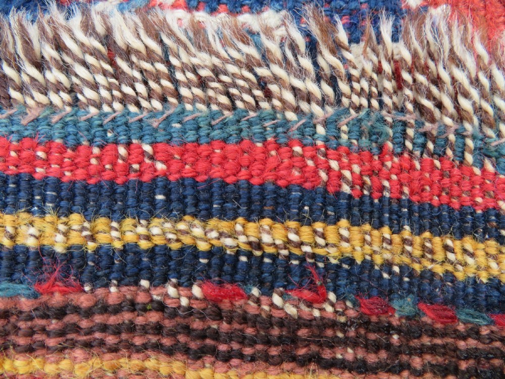 An antique hand-knotted wool kelleh rug featuring a central tree of life motif in red, yellow, and light blue against a dark navy field. View XIX