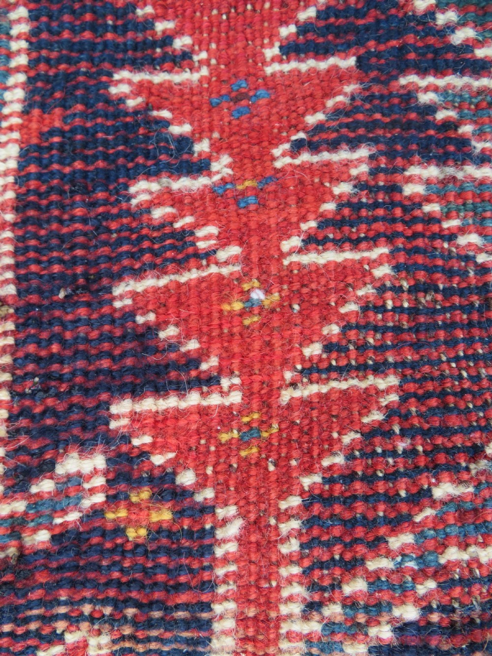 An antique hand-knotted wool kelleh rug featuring a central tree of life motif in red, yellow, and light blue against a dark navy field. View XX