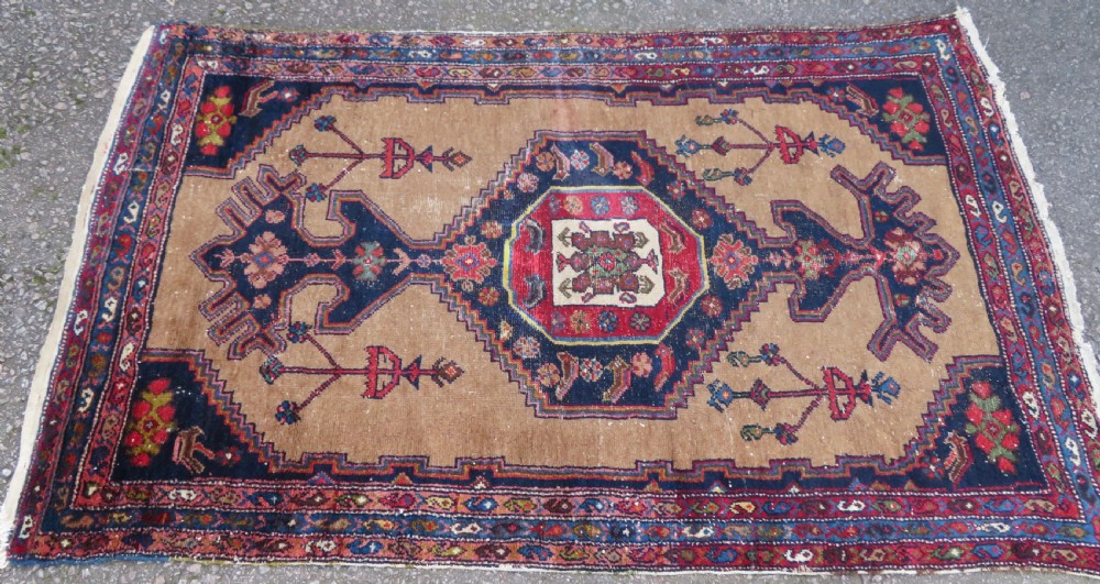 An antique hand-knotted Persian Hamadan wool rug featuring a geometric central medallion on a camel field with navy and red accents. View II