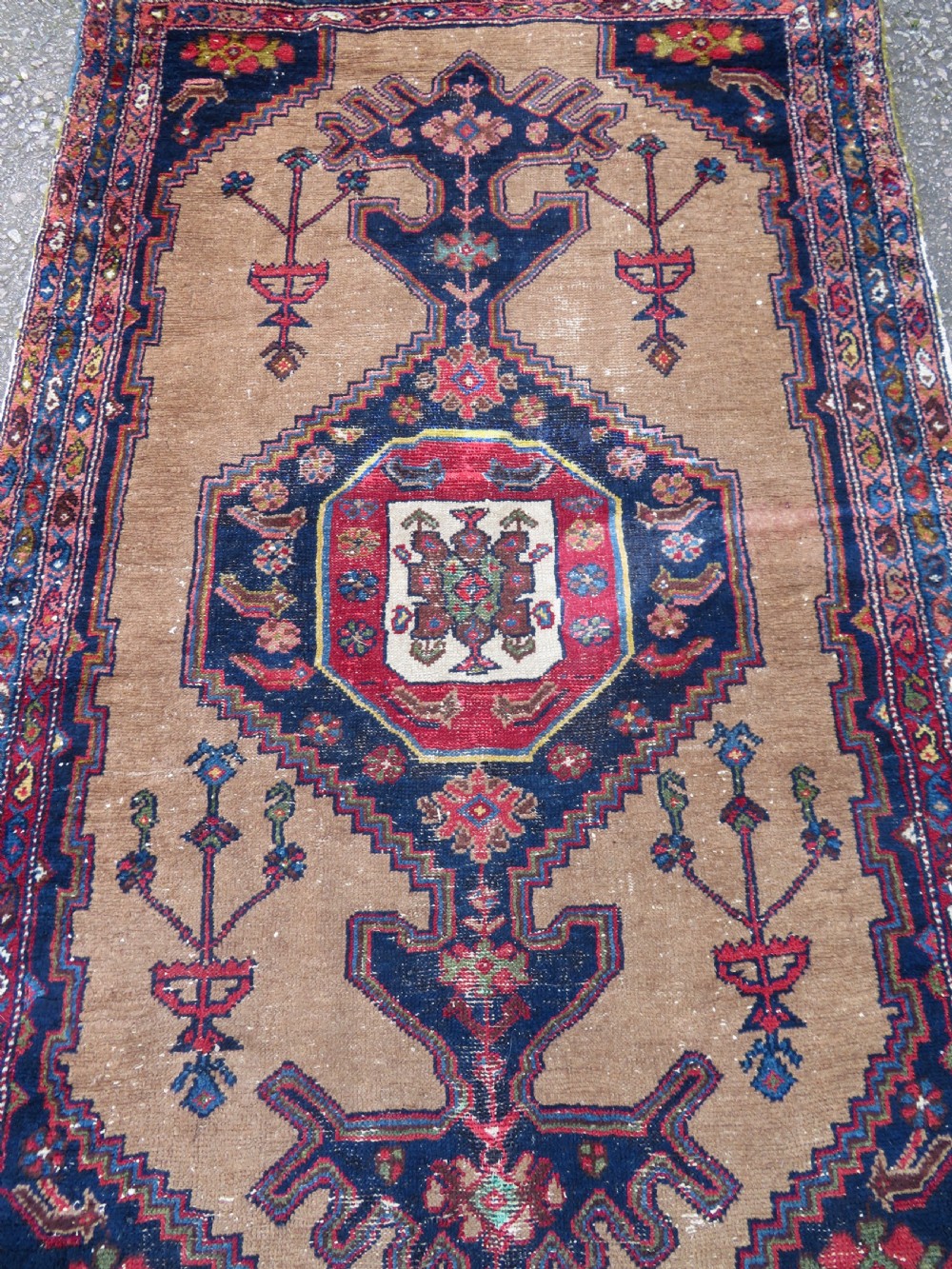 An antique hand-knotted Persian Hamadan wool rug featuring a geometric central medallion on a camel field with navy and red accents. View III
